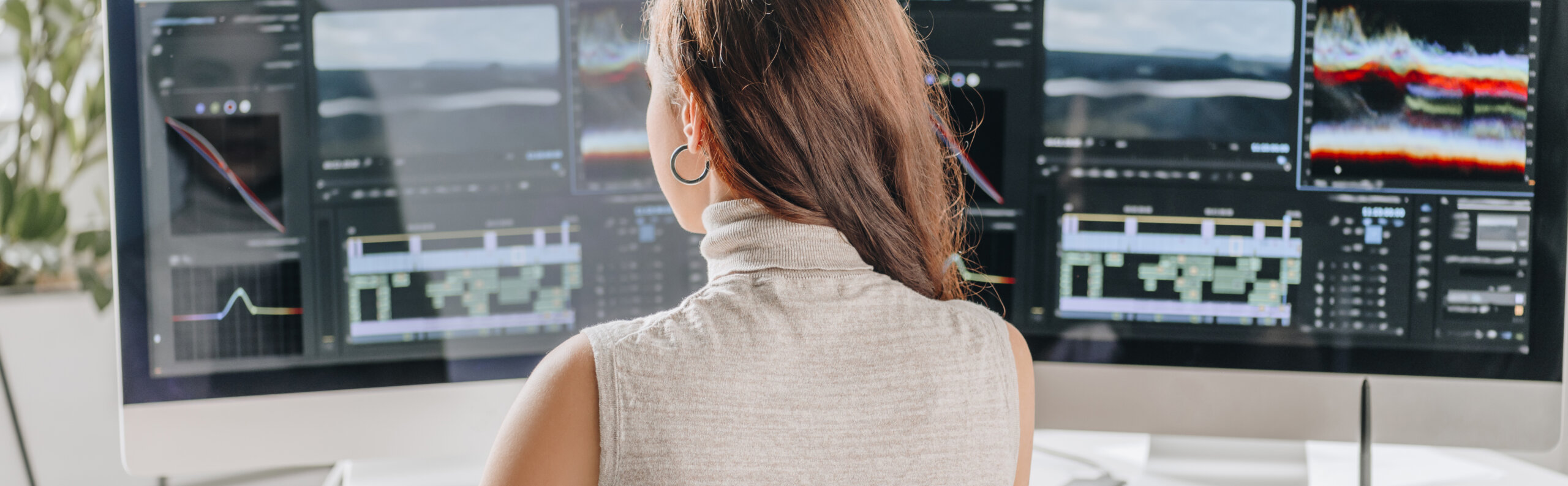 panoramic shot of filmmaker working near computer monitors